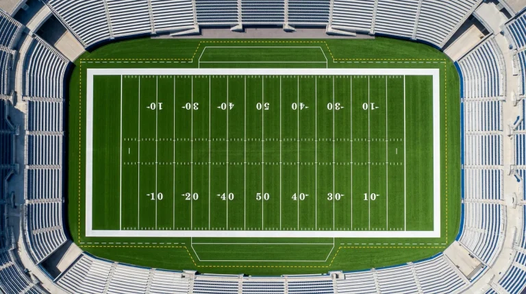 Vista aérea de un campo de fútbol americano con las líneas de yardas claramente visibles